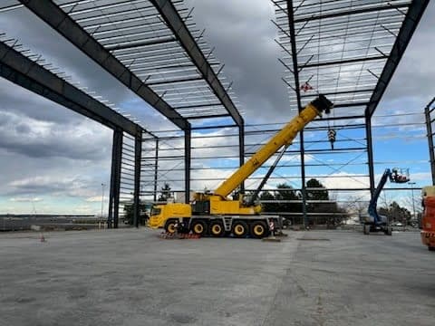 All-terrain crane working inside the completed steel shell of a commercial building