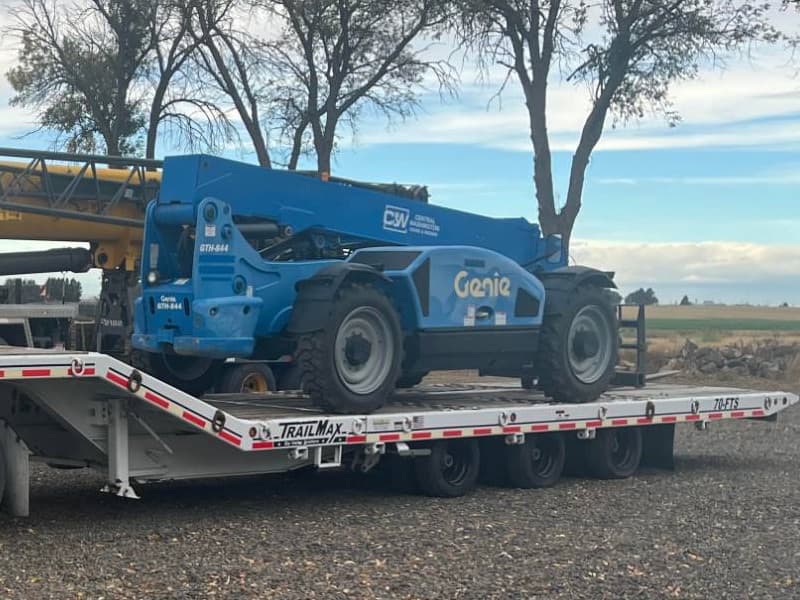 CW Crane & Rigging Genie GTH-844 telehandler loaded on a lowboy trailer for transport to a jobsite